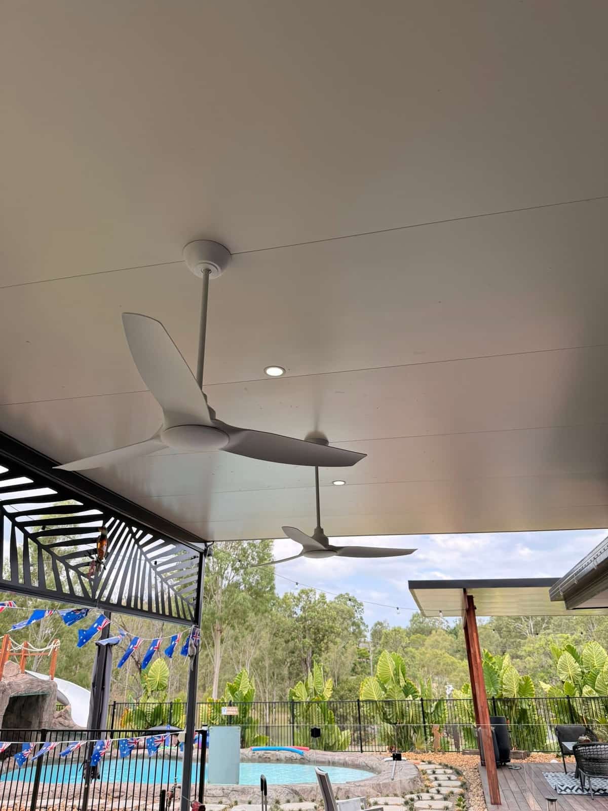 Outdoor ceiling fans and downlights on a covered patio beside a pool, Logan City